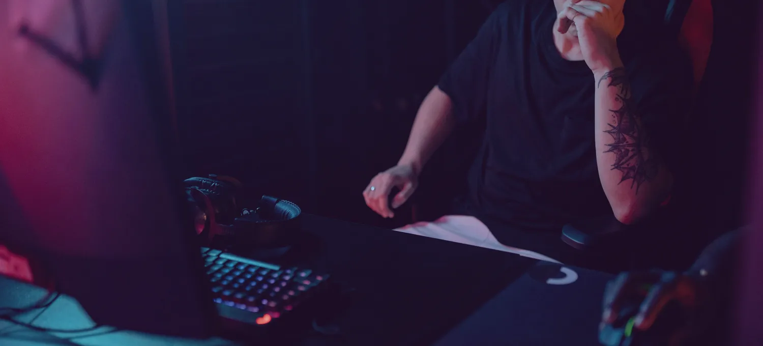 A focused player at a modern online-poker setup at night